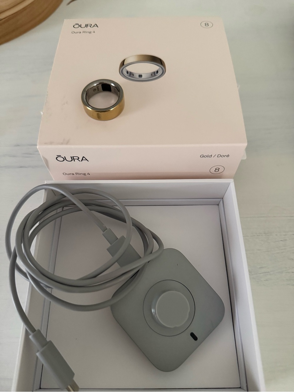 Oura Ring 4 Smart Ring in Gold with Gray Charger